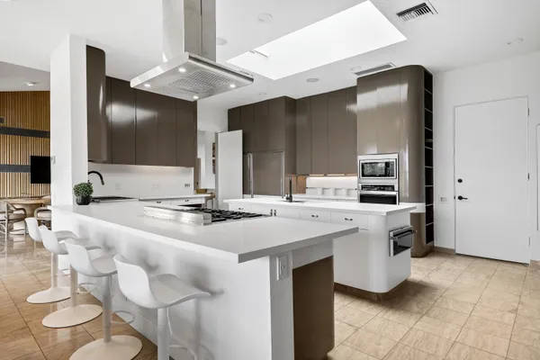 a kitchen with a sink and chairs