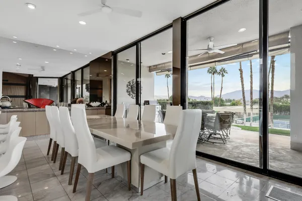 a dining room with furniture water view and a floor to ceiling window