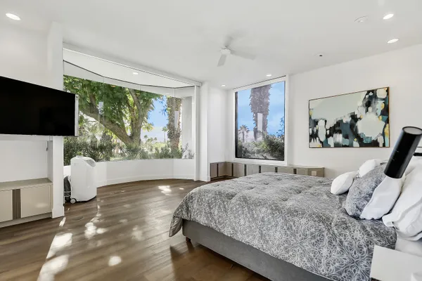 a bedroom with a large bed and a flat screen tv