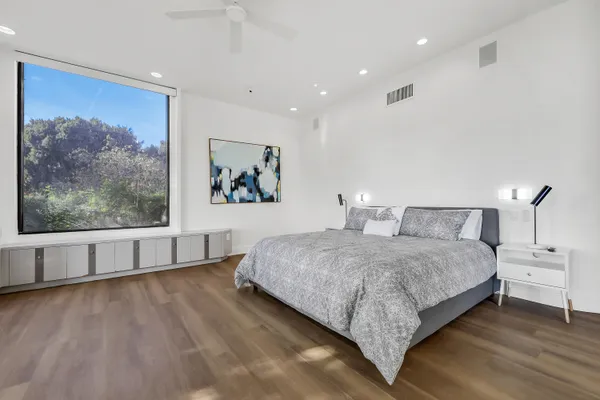a spacious bedroom with a large bed and a painting on the wall