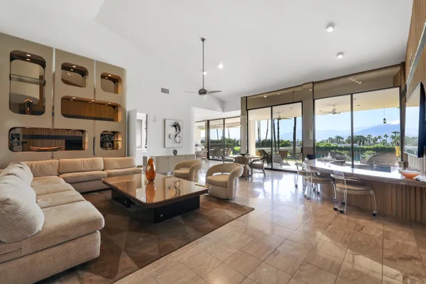 a living room with fireplace furniture and a large window