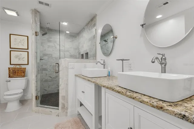 a bathroom with a granite countertop sink mirror and toilet