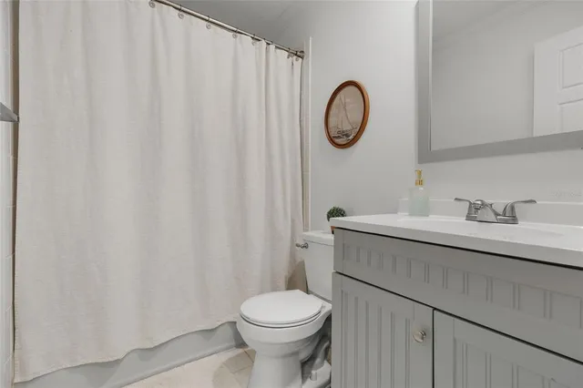 a bathroom with a toilet sink vanity and mirror