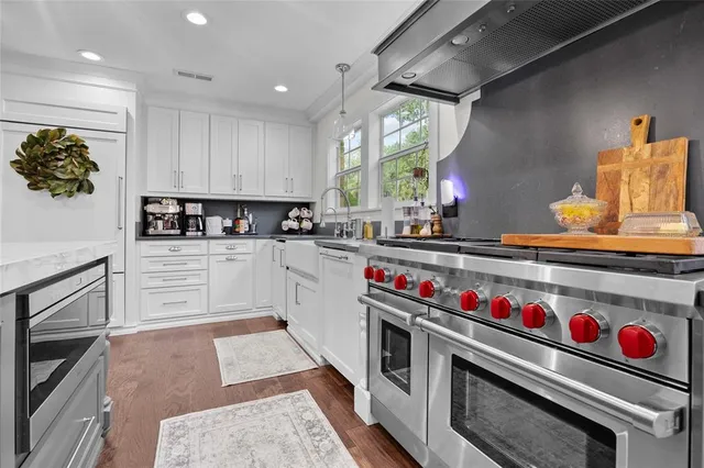 a kitchen with stainless steel appliances granite countertop a stove a sink and a refrigerator