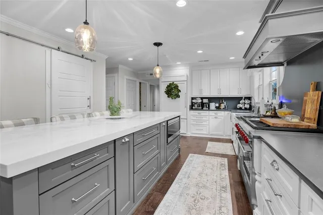 a kitchen with kitchen island granite countertop a sink stove and cabinets