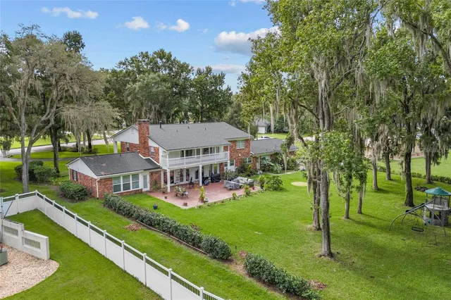 an aerial view of a house with swimming pool and a big yard