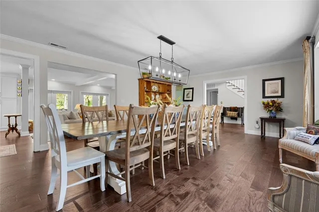 a dining room with furniture a chandelier and wooden floor