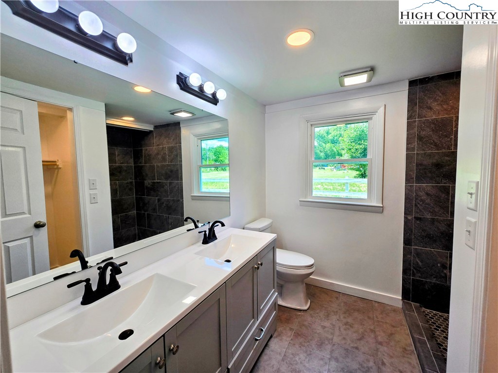 1207 Meat Camp Road Boone, NC 28607 - Photo 11 of 24 a bathroom with a double vanity sink toilet and a mirror