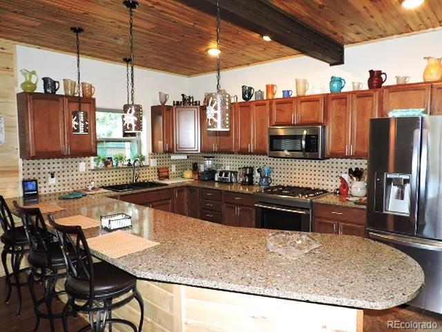 2137 Riccardo Lane Fort Garland, CO 81133 - Photo 15 of 50 a kitchen with stainless steel appliances granite countertop a sink a stove and a refrigerator