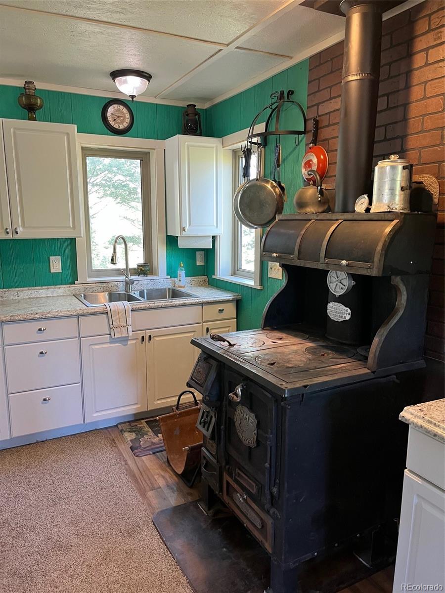 2137 Riccardo Lane Fort Garland, CO 81133 - Photo 44 of 50 a kitchen with stainless steel appliances granite countertop a stove a sink dishwasher and cabinets with wooden floor