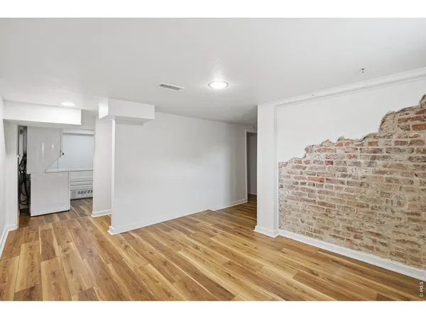 a view of empty room with wooden floor