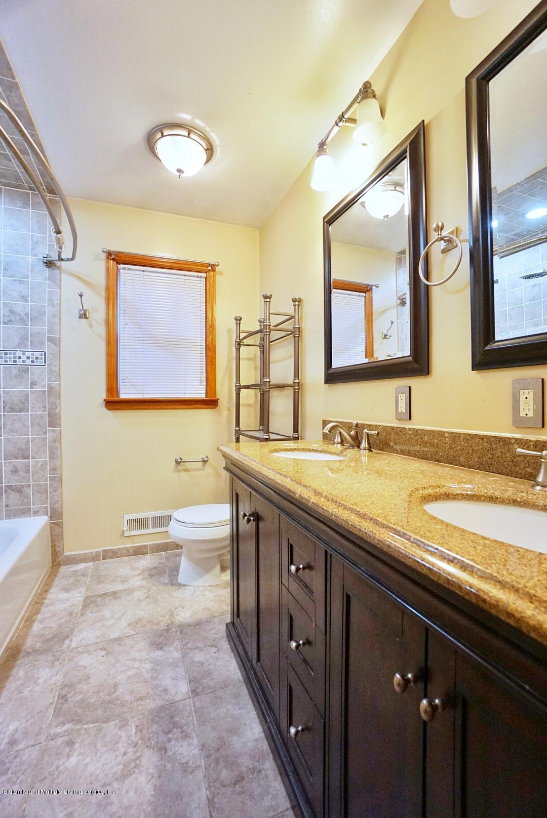1099 Richmond Road Staten Island, NY 10304 - Photo 12 of 28 a spacious bathroom with a granite countertop double vanity sink a mirror and a bathtub