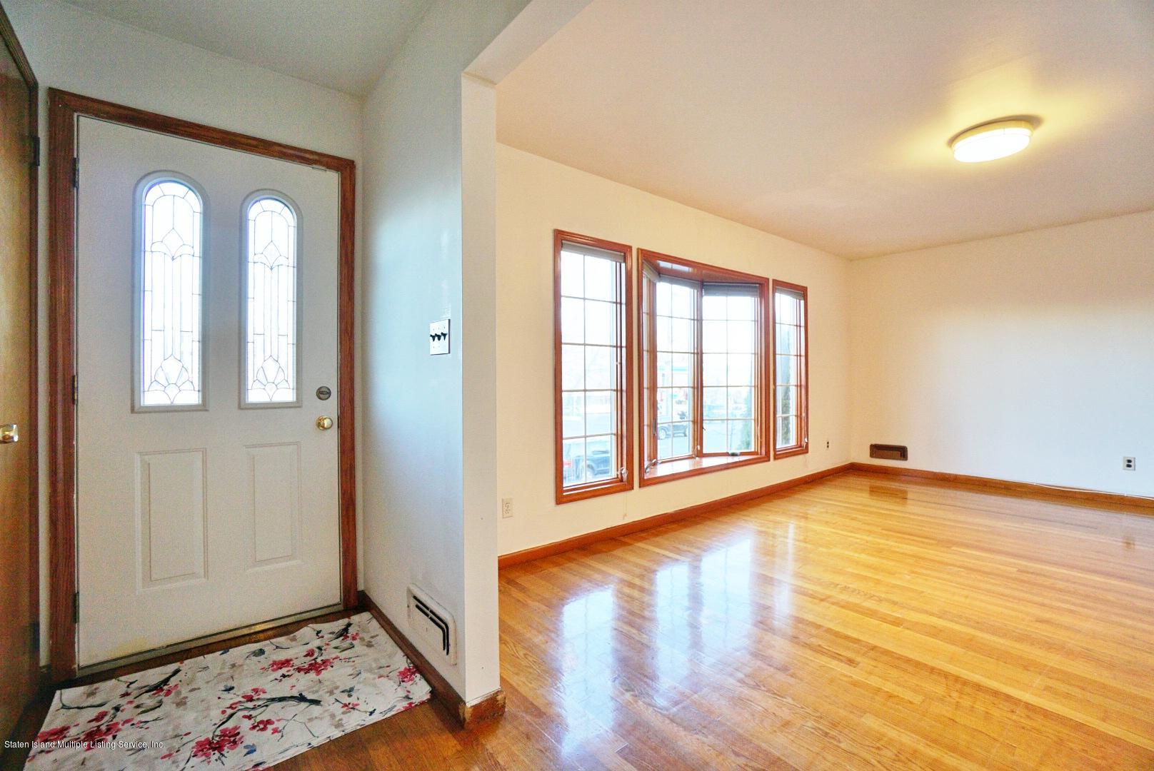 1099 Richmond Road Staten Island, NY 10304 - Photo 5 of 28 a view of an empty room with wooden floor and a window