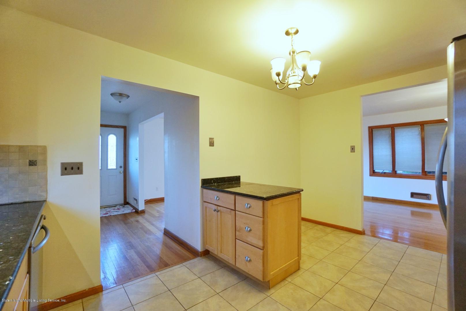 1099 Richmond Road Staten Island, NY 10304 - Photo 8 of 28 a view of a hallway with wooden floor and a chandelier