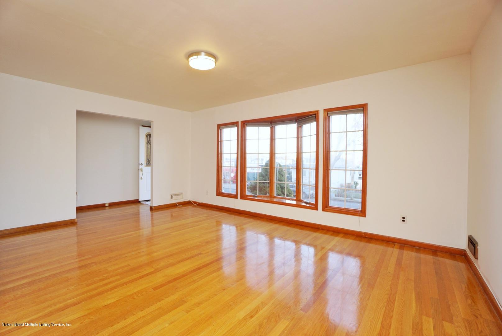 1099 Richmond Road Staten Island, NY 10304 - Photo 9 of 28 wooden floor in an empty room with a window