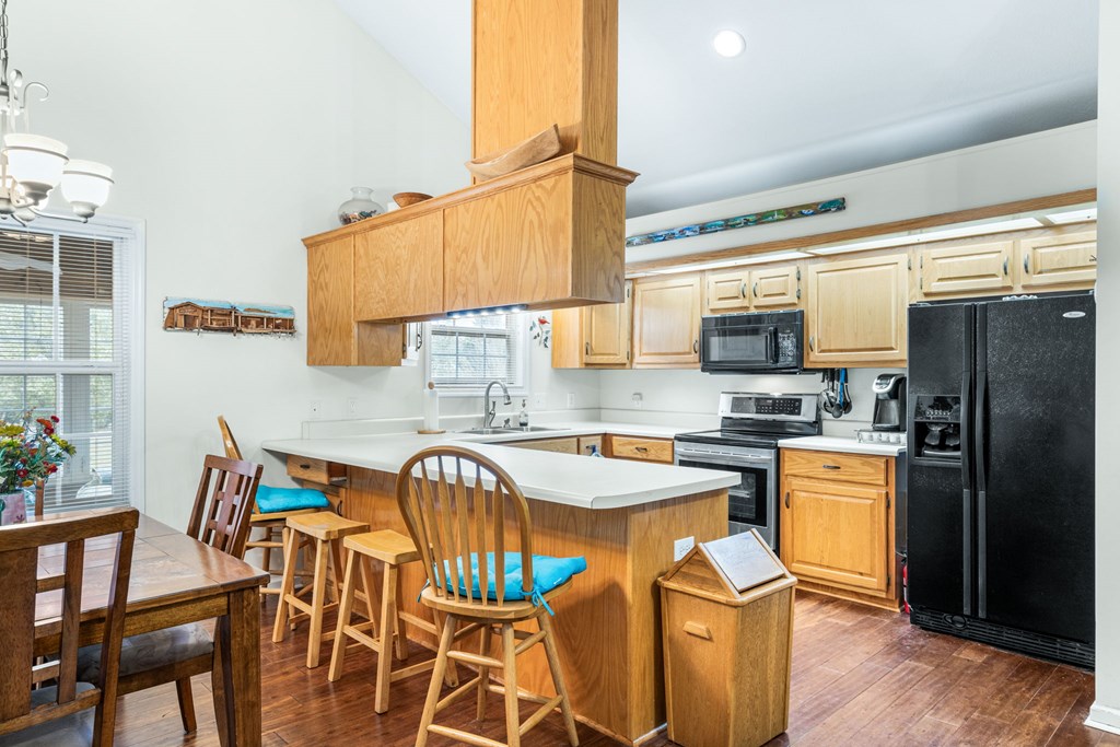 251 Rivers Edge Drive Hayesville, NC 28904 - Photo 14 of 45 a kitchen with stainless steel appliances granite countertop a sink dishwasher a stove a refrigerator with a dining table and chairs