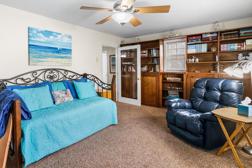 251 Rivers Edge Drive Hayesville, NC 28904 - Photo 19 of 45 a living room with furniture a ceiling fan and a book shelf