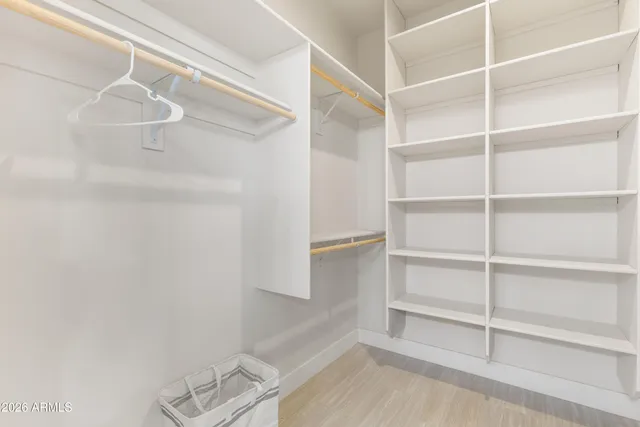 a view of an empty room with window and closet area