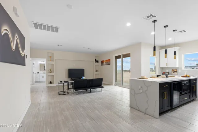 an empty room with wooden floor closet and windows