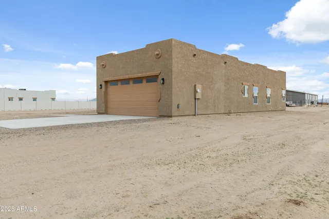 a view of a big house with wooden fence