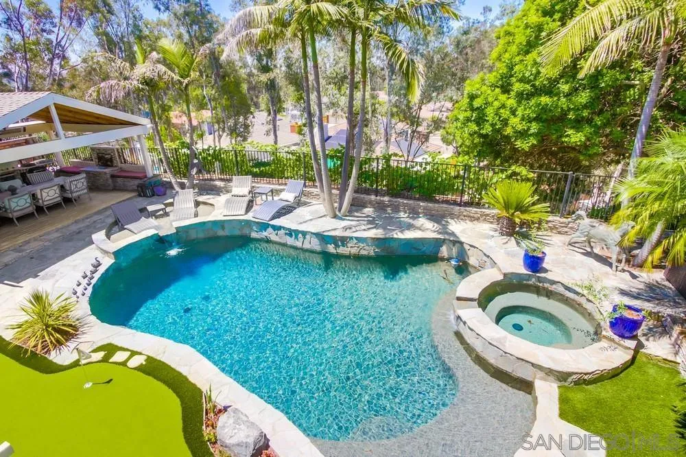 10616 Falcon Rim Point San Diego, CA 92131 - Photo 39 of 44 a view of a swimming pool with lawn chairs under an umbrella