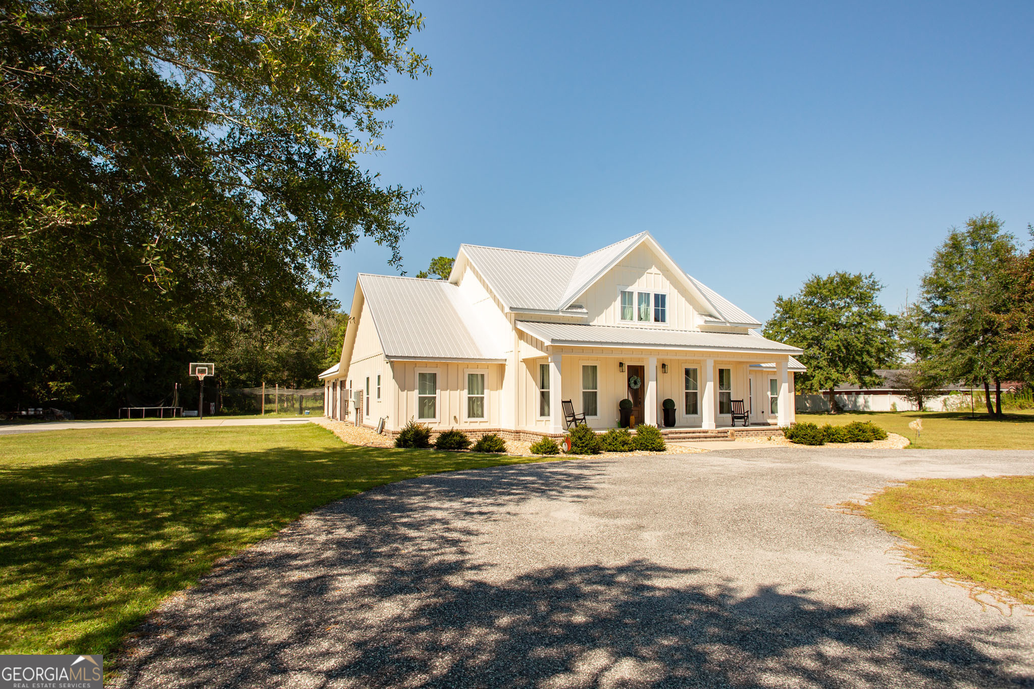 a front view of a house with a yard and trees