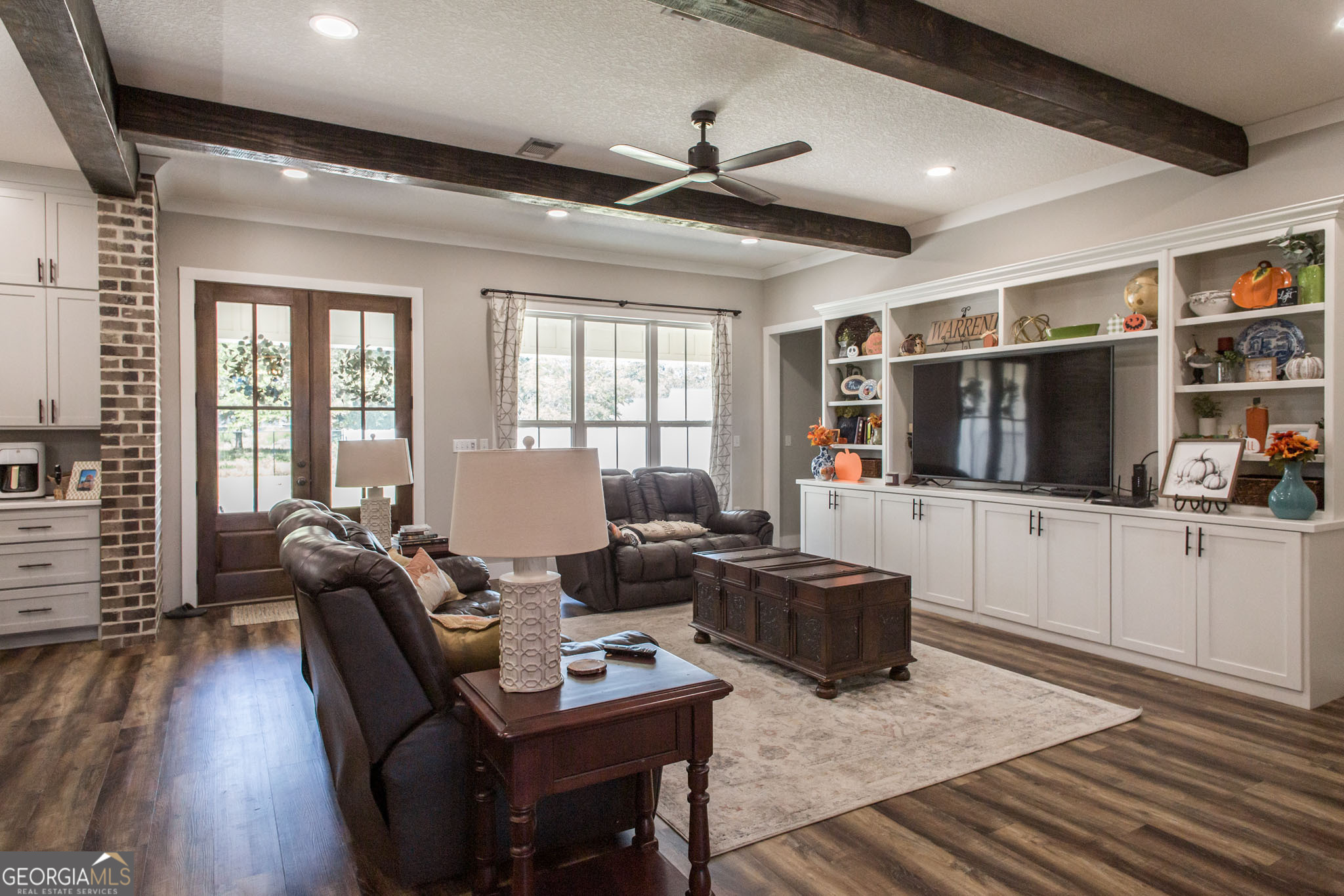664 Saddle Circle Waycross, GA 31503 - Photo 12 of 39 a living room with furniture a flat screen tv and a floor to ceiling window