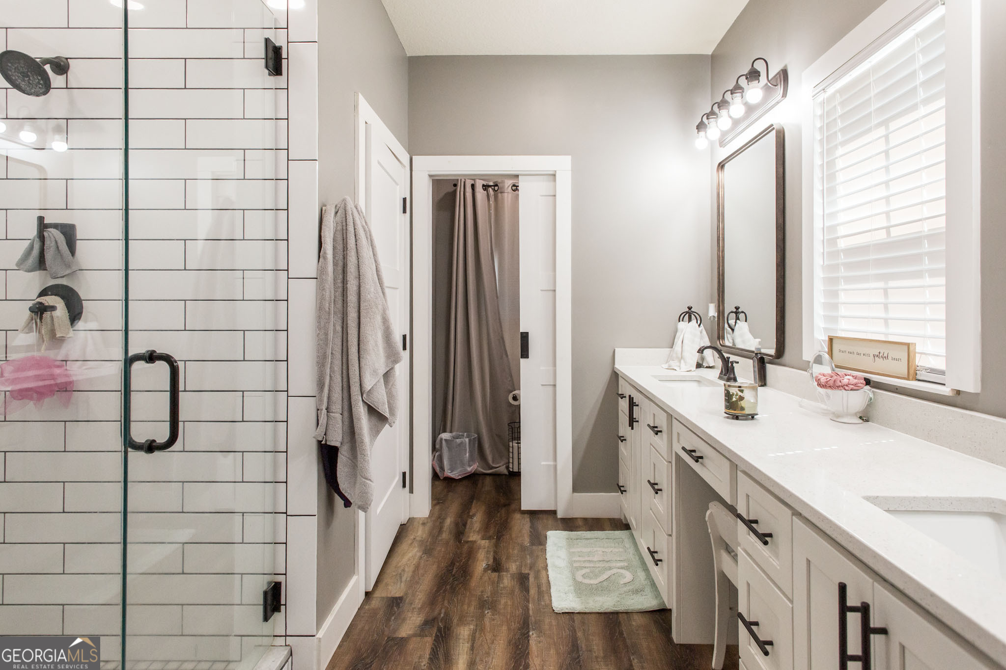 664 Saddle Circle Waycross, GA 31503 - Photo 36 of 39 a bathroom with a double vanity sink a toilet a mirror and shower