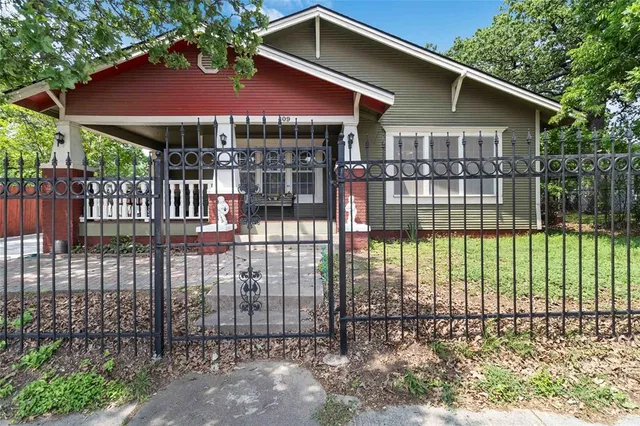 a view of a house with a small yard and wooden fence