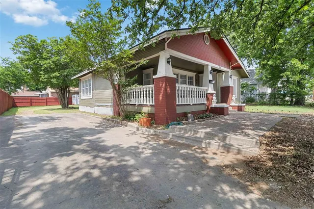 a view of a house with a small yard and wooden fence
