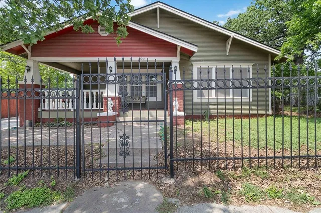 a view of a house with a small yard and wooden fence