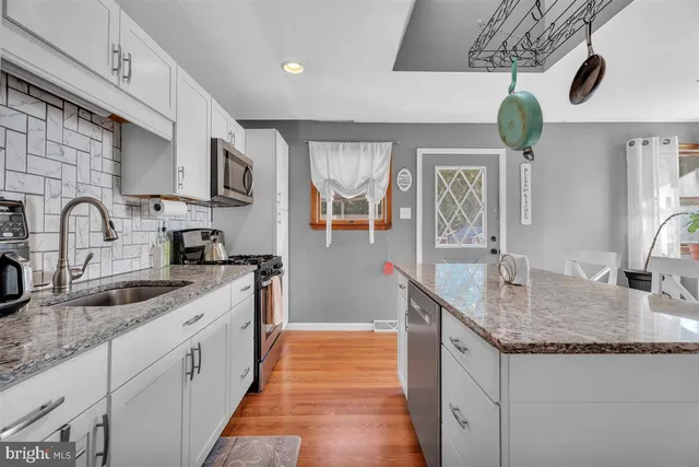 a kitchen with granite countertop a sink a counter top space and cabinets