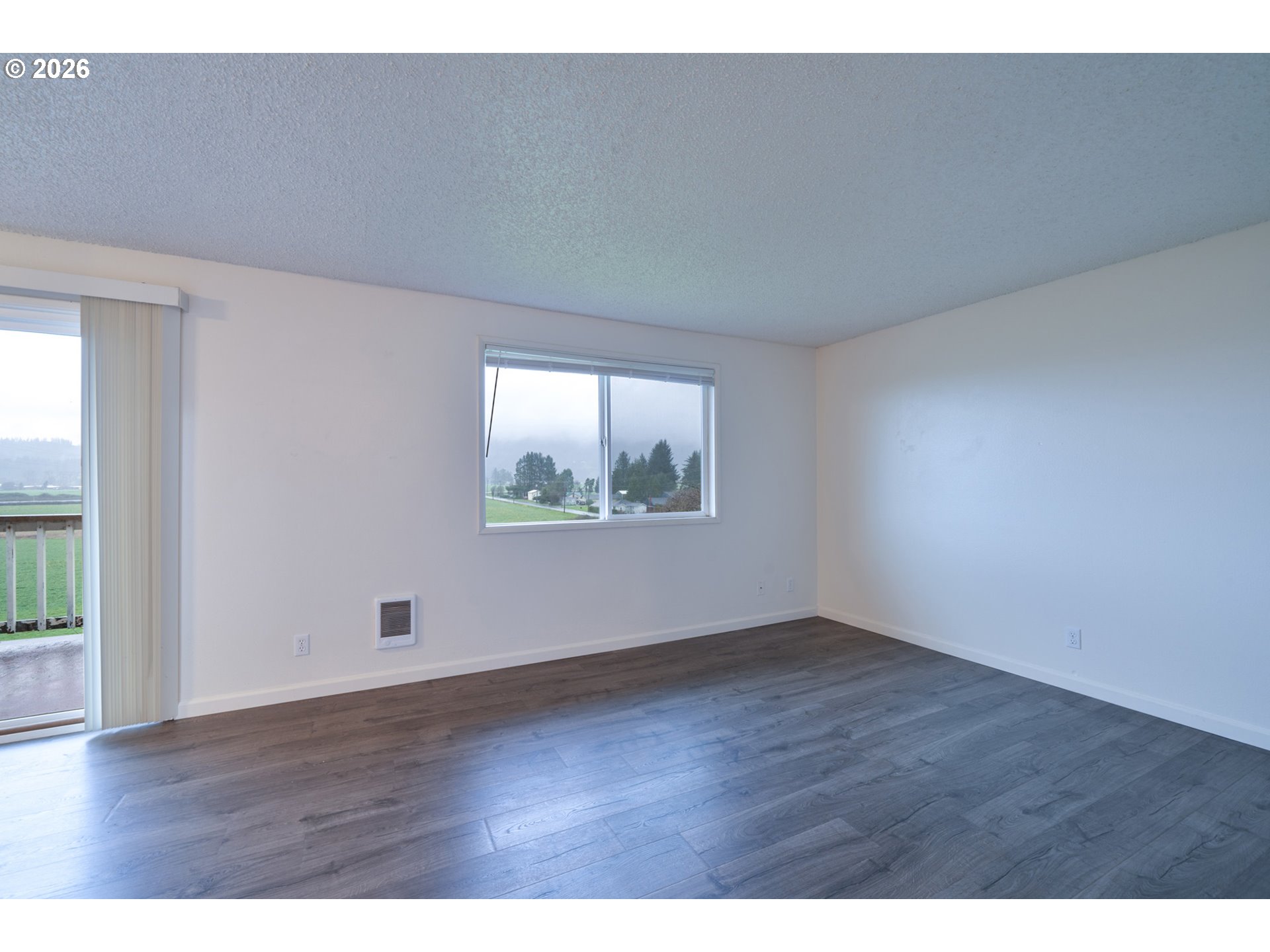 5514 3rd Street Tillamook, OR 97141 - Photo 11 of 25 an empty room with wooden floor and windows