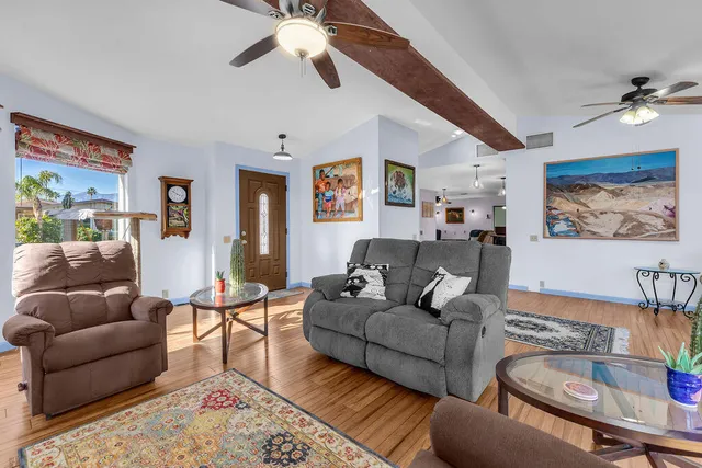 a living room with furniture ceiling fan and a wooden floor