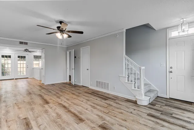 a view of an empty room with window and stairs