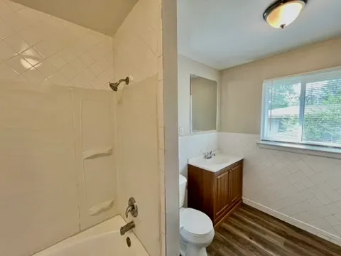 a bathroom with a toilet a sink and mirror