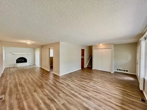 a view of empty room with wooden floor and window