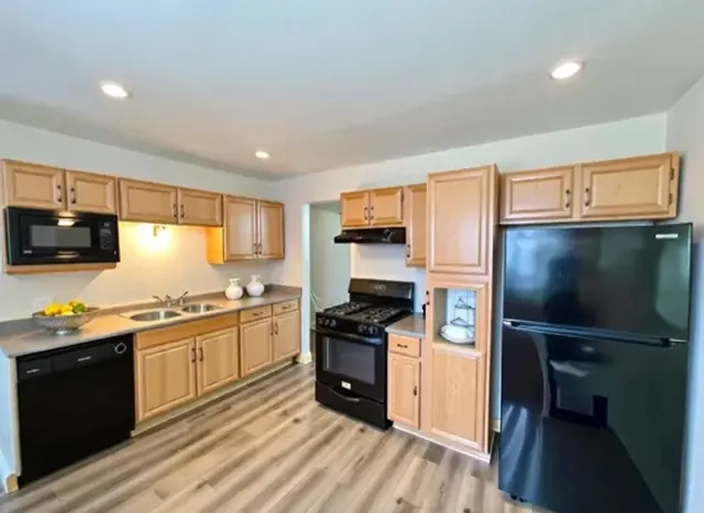 a kitchen with granite countertop a refrigerator stove top oven and sink