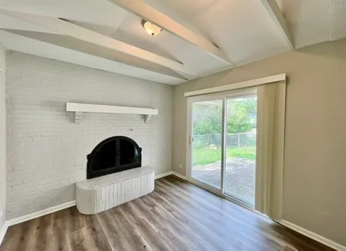 a living room with a fireplace and wooden floor