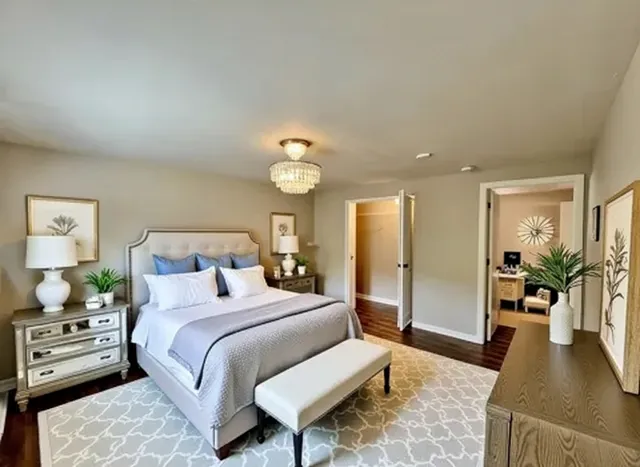 a bedroom with a large bed and a chandelier