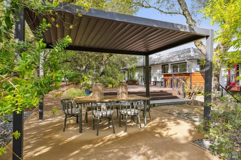 a kitchen with stainless steel appliances kitchen island granite countertop a refrigerator a sink a stove and white cabinets