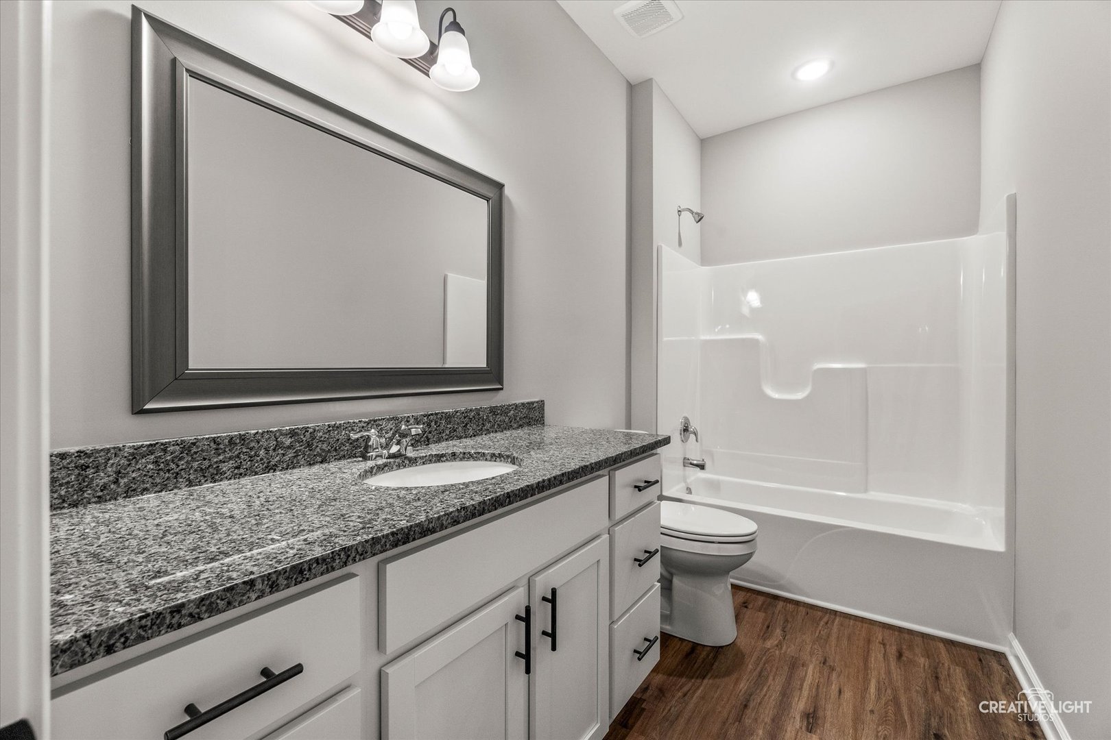 520 Preston Street Cortland, IL 60112 - Photo 14 of 16 a bathroom with a granite countertop sink a toilet and a mirror