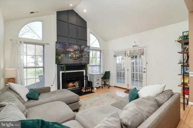 a living room with furniture a fireplace and a floor to ceiling window