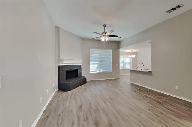 a view of an empty room with a fireplace and a window