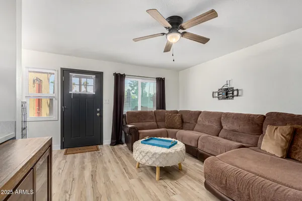 a living room with furniture and a wooden floor