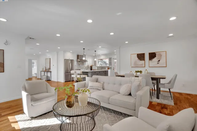 a living room with furniture and a view of kitchen