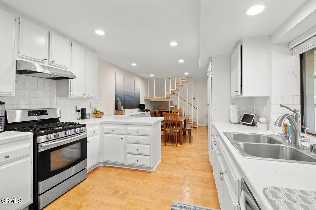 4448 Lubbock Drive, Unit D Simi Valley, CA 93063 - Photo 16 of 19 a kitchen with stainless steel appliances kitchen island granite countertop a sink a stove and a refrigerator