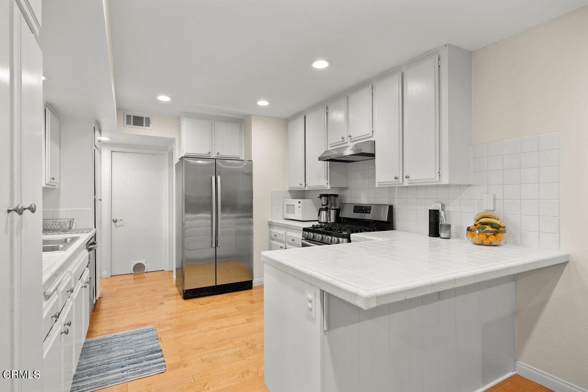 4448 Lubbock Drive, Unit D Simi Valley, CA 93063 - Photo 17 of 19 a kitchen with a sink a refrigerator a stove and cabinets