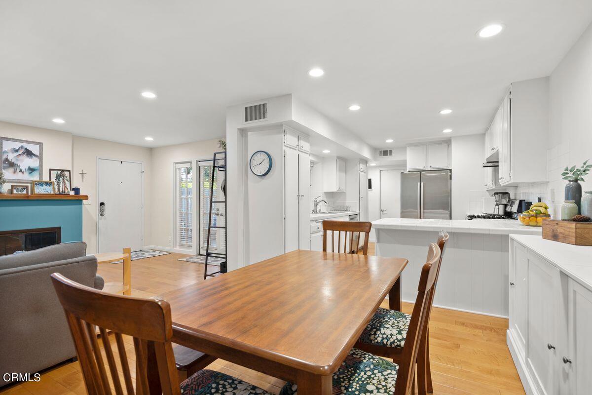 4448 Lubbock Drive, Unit D Simi Valley, CA 93063 - Photo 18 of 19 a kitchen with stainless steel appliances granite countertop a dining table chairs refrigerator sink and cabinets