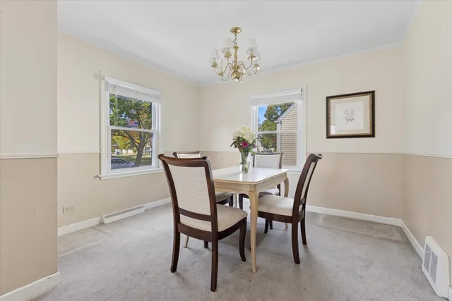 a view of a dining room with furniture and a chandelier